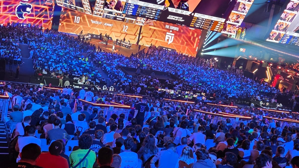 Het scherm in de zaal toont de halve finale tussen FUT Esports en FURIA, met het publiek in de tribunes