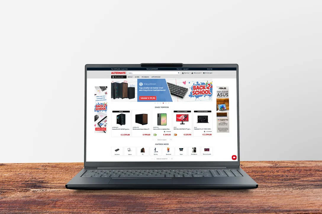 Laptop op een houten bureau met de webshop van ALTERNATE op het scherm